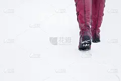 红色，皮革，女靴走在白色，新鲜的雪地上。享受漫步。冬季日常行走的鞋。文本、引用或语录的空地方。后视图