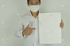 商人戴着医用口罩，手指着空白的纸张