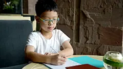 男孩在桌子上做作业