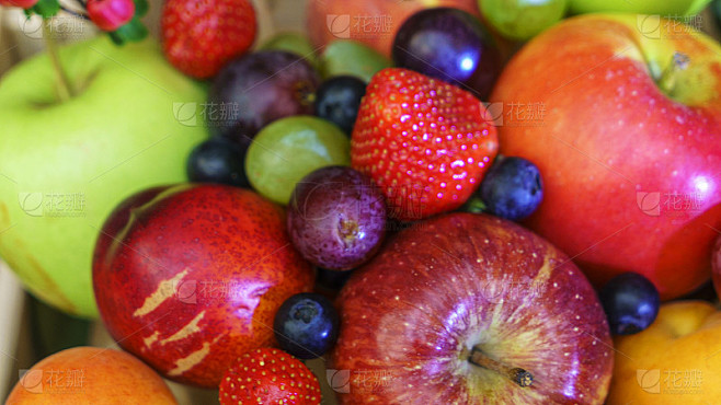 夏季水果，浆果分类。大苹果、李子、杏子、葡萄和草莓。五颜六色的浆果装在木箱里放在桌子上。
