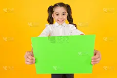 被布置家庭作业。黄色背景上的幼儿手持空白纸进行检查工作。小女孩与空白绿纸项目工作或研究。文书工作，复