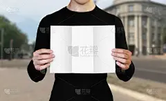 一个拿着一张白纸的男人。拿着一本小册子。关闭了。城市的背景