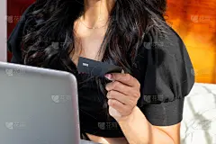 特写的拉丁妇女采取信用卡购买网上与她的笔记本电脑