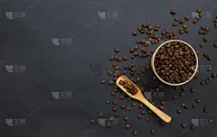 旧的黑色木桌背景上放着咖啡豆。创建问候，卡片，杂志，封面，海报和横幅等文本空间的模型和模板。前视图。