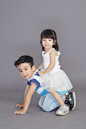Girl in White Dress Sitting on Crawling Boy's Back