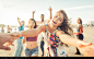 Group of friends having fun and dancing on the beach - stock photo