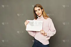 年轻的微笑的女人与空白的白纸