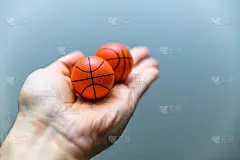 特写手拿着两个橙色的篮球像鞋子清新球。