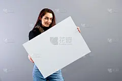年轻女子的肖像显示空白招牌与拷贝空间，孤立在灰色