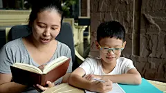 男孩和妈妈在桌子上做作业