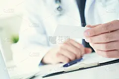 男性医师手握和给白色空白名片特写在办公室。联系信息交流，正式会议介绍手势，个人或家庭医生概念