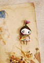 Small flower doll : This is a small flower doll made of fabric .  She is almost 6 cm tall (2.36 inches) , including the flower.  She comes in a handmade stylized cardboard