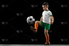 男孩的全身肖像，孩子，足球运动员在统一训练孤立在黑色背景。