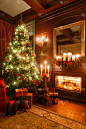 圣诞树上的礼物。烛光下的圣诞夜。带壁炉的经典公寓.