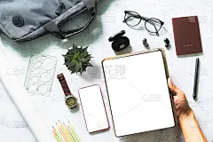 在白色办公桌上的平板电脑屏幕上工作，从俯视图可以看到商务人士用白色办公桌上的数字设备模型、用品和装饰