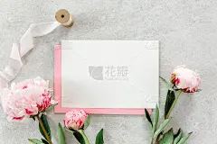 邀请模型，空白纸贺卡，粉红色信封和牡丹在灰色的石头桌上。花的背景。平躺，俯视图
