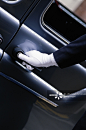 Man wearing white gloves, close-up of hand on car door handle_创意图片