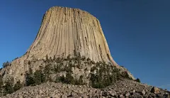 搜罗全美岩石景观 美国奇形怪石
9.怀俄明州的魔鬼塔国家纪念碑
　　当你看到这座纪念碑时，一切其他的景观都显得渺小了，它在怀俄明州的东北部，高达867英尺。这座纪念碑并不是火山喷发的残骸，而是岩浆从地底喷发出来而后冷却的产物。当周围的石头渐渐被侵蚀，这座圆柱状的类似熊爪印的“建筑”就形成了，很多美国土著居民把这座“纪念碑”看做是很神圣的存在。
　　纪念碑旁有一条大约8英里的道路，这条路引领游客穿过草地和黄松木。护林者还会带领游客到达纪念碑，而游客中心也会提供有关当地的地理、生物、文化展览。
　　对于攀岩爱