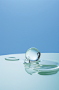 water drop, silver ball, silver plate with cloudy, reflecting surface, white & green, in the style of tokujin yoshioka, playful shapes, conceptual minimalism, tabletop photography, light sky-blue, curved mirrors, delicately rendered landscapes