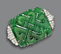 CARVED JADE AND DIAMOND BROOCH, CIRCA 1930.  The jade plaque carved with an intricate knot symbolizing luck, bordered by segments of baguette and single-cut diamonds at the sides, weighing a total of approximately 1.15 carats, mounted in platinum.