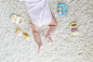 婴儿的身体和腿部有许多丰富多彩的拨浪鼓玩具的特写镜头.