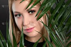 女人的蓝绿眼睛，瞳孔异色，漂亮的妆容和浓浓的眉毛。看着摄像机。专业的化妆美容。