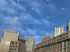 以蓝天为背景的高层建筑。有镜面窗户的新高楼，俯视风景。背景纹理:办公楼。