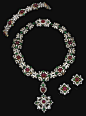 RUBY, EMERALD AND DIAMOND PARURE. Comprising: a pendant necklace designed as a series of graduated cabochon rubies in pinched collets set with scroll borders of cabochon emeralds and brilliant-cut diamonds, the pendant detachable and wearable as a brooch,