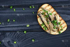 三明治的小子。小人物在油中。在黑色的背景上