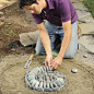 Mark Powers filling in the spiral pattern in his pebble mosaic More: 