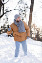 戴着帽子和围巾的积极向上的男人，在外面的雪地里望着远方 