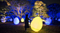 Resisting and Resonating Ovoids and Trees and Breathing Resonating Stone Wall - Fukuoka Castle Ruins | teamLab / チームラボ : ・Resisting and Resonating Ovoids 放置在古城遗迹中的持续不断站立的物体和遗迹中的树木一起发出光芒。每棵树上的光会个别自我行动，像是在呼吸一样一下发出强烈光芒，一下变得灰暗。每棵树上的光在被人推倒时，会改变光芒的颜色，并且发出特