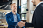 Two businessman shaking hands in a cafe by Milenko Đilas on 500px