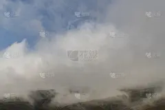 美丽的山景，巨大蓬松的云朵降落到山顶。自然山壁纸。