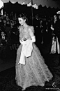 摄于1947年7月- Elizabeth公主和她的未婚夫到达Caledonian酒店参加Duchess of Buccleugh盛请的晚宴。当晚，公主选择了公主式的童话风格礼服，细节处在于整体的纱质围边设计，搭配上一对白手套和珍珠项链，散发着高贵优雅的皇室气质。