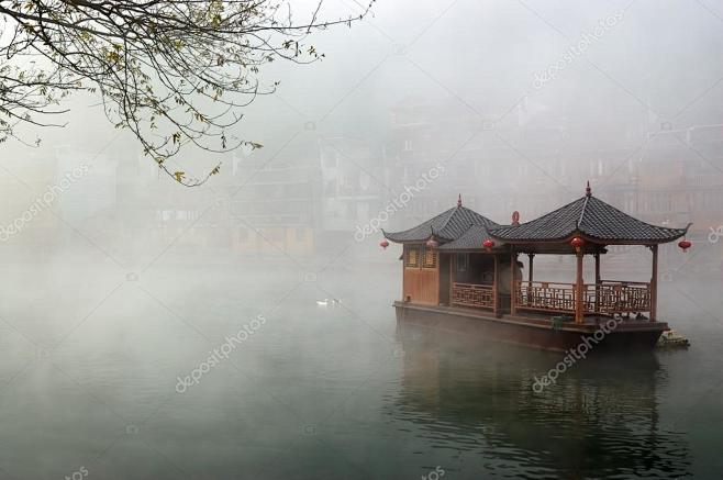 中国景观的船上有雾河与湖南省的传统建筑背...