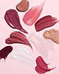 Swatches of lipgloss on a pink background by cosmetic photographer Teri Lyn Fisher. 