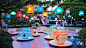 Giant teacup on a spinning table rest below hanging lanterns beside the Matterhorn Bobsleds