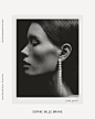 a black and white photo of a woman with earrings