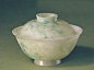 翠玉雕花盖碗，此盖碗翠玉质地，粉白色地子中有绺绺绿色。碗圆形，带盖，圈足。盖面和碗外壁凸雕缠枝莲纹。