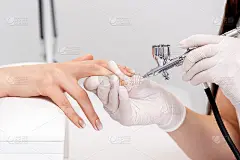 美甲大师使用喷枪。