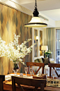 沙发背景以复古的绿棕色系菱格壁纸搭配直线型白色显纹木质线条，与餐厅背景遥相呼应，延伸了客餐厅的空间统一感。