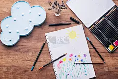 子绘图顶视图。艺术品工作场所与创意配件。桌上放着女儿画的画