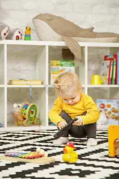 可爱的小女孩在育婴室玩玩具