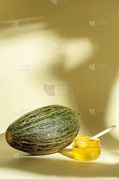 近距离观看鲜甜瓜与蜂蜜在黄色背景与阴影。有创意的海报。食物照片概念与复制空间。夏日甜果为餐后甜点。