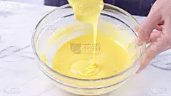 将蛋黄混合到蛋糕面糊中，用绿橡皮刮刀搅拌至顺滑，并在玻璃碗中充分混合。