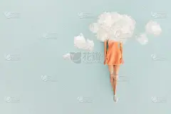 可爱美丽的女娃娃在一个柔和的蓝色背景上，一个头在云盘旋在橙色的裙子。最小的创意概念与复制空间。想象力