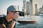 Man Wearing Gray Cap Taking Photograph Using Camera