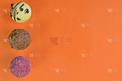 橘色粉彩背景的巧克力夹心糖或果仁糖。各种各样的巧克力果仁在橙色的背景与复制空间。平躺，俯视图