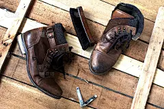 棕色皮靴和木质地板上的鞋刷